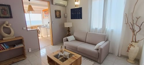 Salon moderne du gîte Clémara Evasion en Martinique avec canapé beige, vue sur mer et décoration côtière
