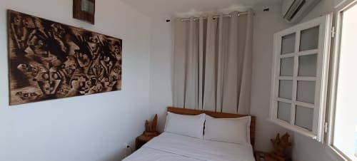 Chambre lumineuse de l'appartement Oasis à Clémara Evasion, Schœlcher, avec lit en bois, portes avec vue mer et décoration murale