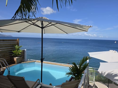 Piscine face mer de Clémara Evasion avec parasols surplombant la mer des Caraïbes à Schœlcher, Martinique