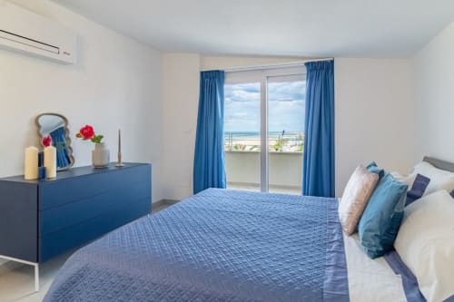 Modern bedroom with blue furnishings, sea view balcony, and contemporary décor at Pescara INN, Pescara