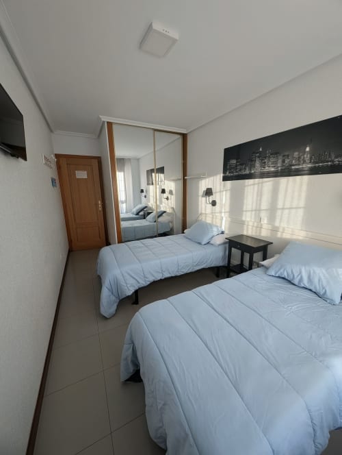 Double room with two beds at La Ballena B&B in Santoña, featuring shared bathroom and city view