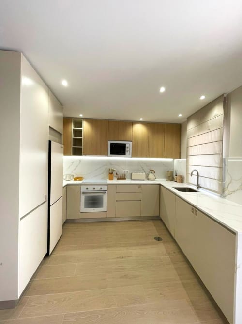 Cozinha moderna com armários em madeira, revestimento em mármore e eletrodomésticos em aço inoxidável no apartamento Casa da Villa, Figueira