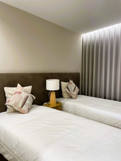 Quarto duplo moderno na Villa Sotto Mayor com vista para o mar, roupa de cama branca, luminária dourada e cortinas do chão ao teto
