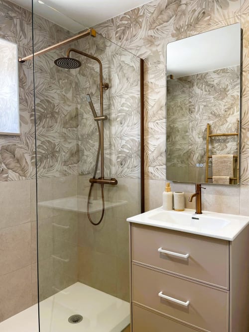 Banheiro moderno com azulejos botânicos, chuveiro em nicho com acabamentos em bronze e lavatório na Villa Sotto Mayor
