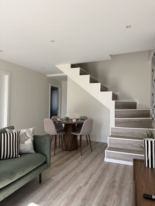 Apartamento Casa Abadias em Villa Sotto Mayor, Figueira da Foz: área de estar moderna com sofá verde, mesa de jantar e elementos em madeira