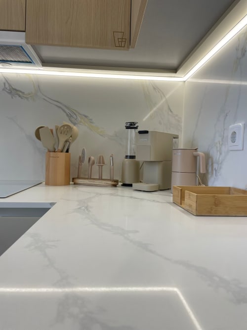 Cozinha moderna com bancada de mármore, acessórios em madeira e eletrodomésticos em aço inoxidável na Casa Abadias, Villa Sotto Mayor