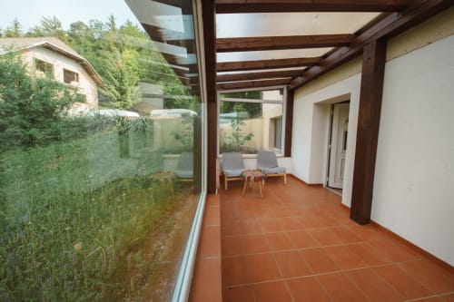 Covered terrace with terracotta tiles and wooden beams at Kmetija Pečnik garden apartment in Prevalje