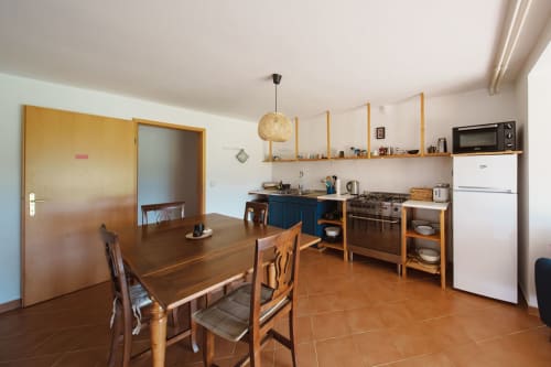 Kitchen-dining area at Kmetija Pečnik in Prevalje with wooden table, blue cabinetry, and modern appliances