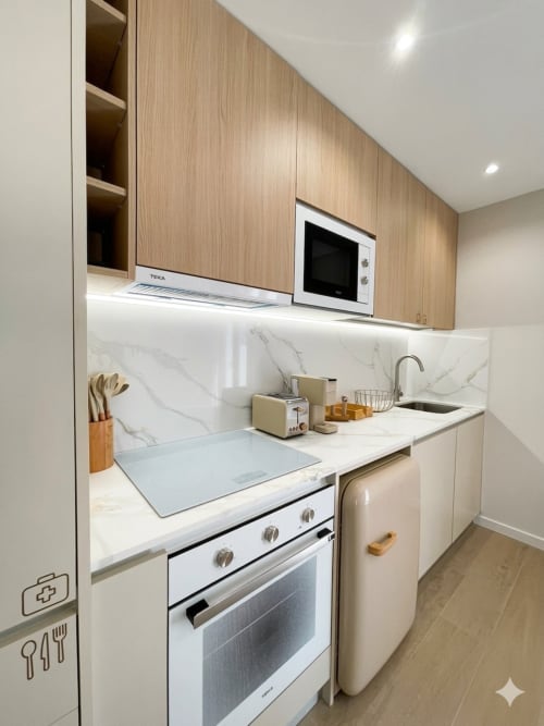 Cozinha moderna do apartamento Casa Ninho na Villa Sotto Mayor, Figueira da Foz, com bancada de mármore e móveis em madeira