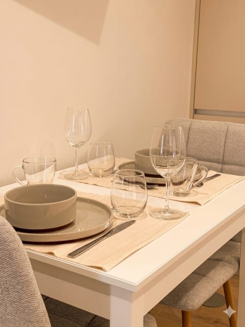 Mesa de jantar elegantemente arrumada no apartamento Casa Ninho da Villa Sotto Mayor em Figueira da Foz, com talheres e copos