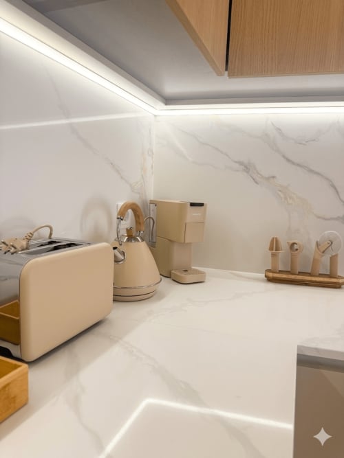 Bancada de cozinha moderna na Villa Sotto Mayor com backsplash em mármore, eletrodomésticos creme e acentos em madeira em Figueira da