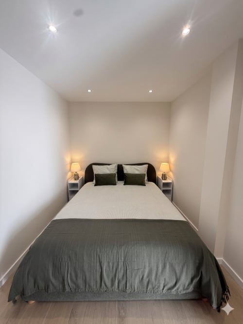 Quarto moderno na Villa Sotto Mayor, Figueira da Foz com cama queen, roupa de cama escura, iluminação ambiente e decoração minimalista