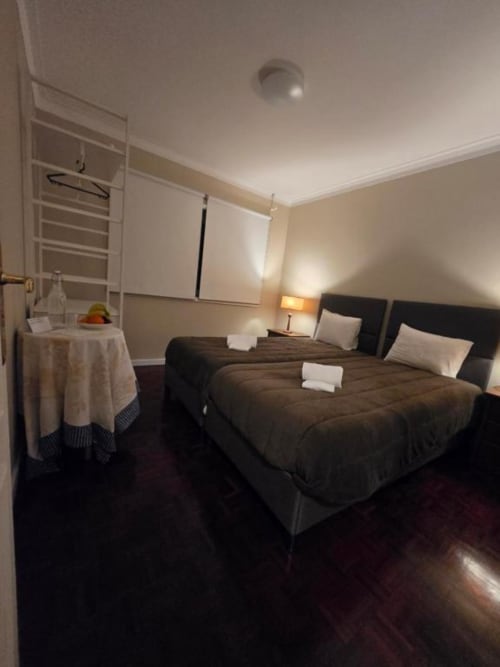 Quarto twin da Casa de Hóspedes Mãe Maria em Vila Chã com camas escuras, iluminação aconchegante e comodidades modernas