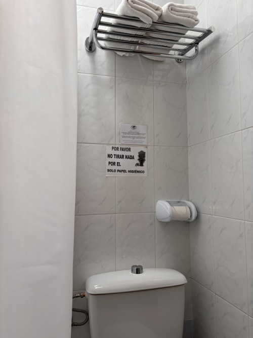Baño limpio en Hostal Las Dunas con inodoro, toallero y aviso de higiene español en Cabo de Gata