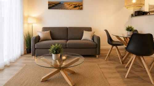Sala de estar moderna en apartamento Gran Reserva Sea Breeze de Holidays Costa Brava con sofá gris, mesa de cristal y madera