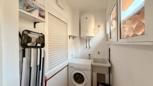 Lavadero con lavadora, fregadero, calentador de agua y almacenamiento en Holidays Costa Brava, Empuriabrava