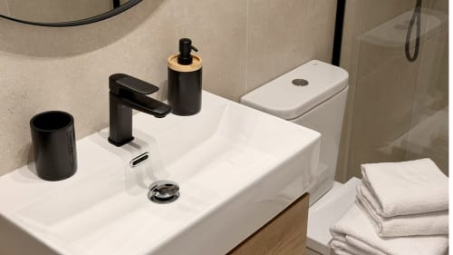 Lavabo moderno en apartamento Gran Reserva Sea Breeze de Holidays Costa Brava con grifo negro y toallas blancas