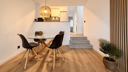 Moderna zona de comedor en apartamento Gran Reserva Sea Breeze de Holidays Costa Brava, Empuriabrava con mesa redonda de cristal y