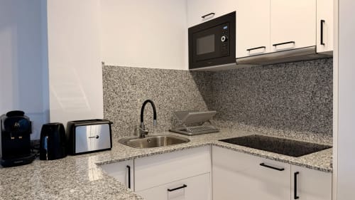 Cocina moderna del apartamento Gran Reserva Sea Breeze en Holidays Costa Brava, Empuriabrava con encimeras de granito y acabados blancos