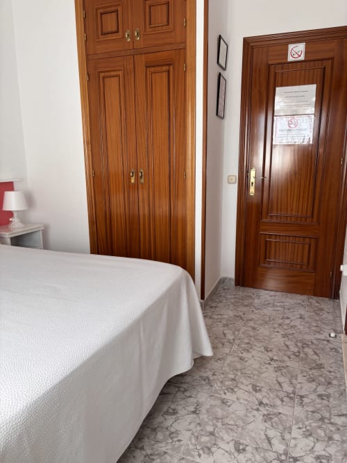 Habitación Single Superior en Hostal Las Dunas, Cabo de Gata, con armario de madera, cama y piso de baldosas