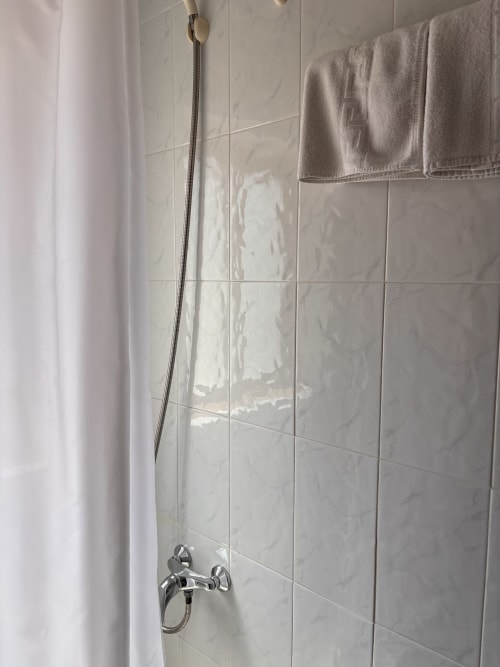 Baño moderno con azulejos de mármol y accesorios cromados en la habitación Single Superior del Hostal Las Dunas, Cabo de Gata
