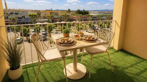 Comedor en terraza de Holidays Costa Brava con mesa, sillas y vistas a la ciudad de Empuriabrava, España