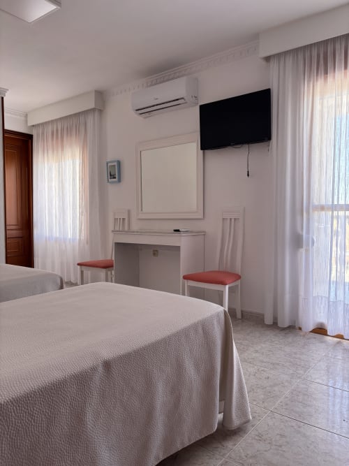 Habitación triple con terraza en Hostal Las Dunas, Cabo de Gata. Camas, TV, escritorio, aire acondicionado y acceso al balcón.