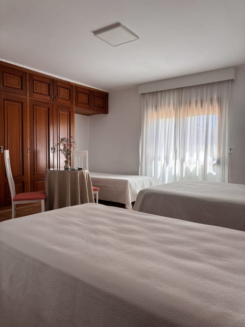 Habitación Triple Superior en Hostal Las Dunas, Cabo de Gata, con camas individuales, armario de madera y vistas al mar