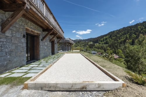 Modern stone chalet with gravel pathway overlooking forested Alpine valley near Les Gets, Scionzier