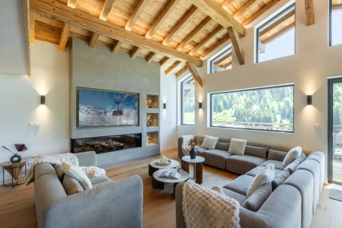Modern luxury villa living room with exposed wooden beams, mountain views, fireplace, and comfortable seating at Altitudia