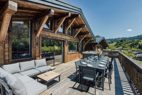 Chalet Magy luxury villa terrace in Les Gets with dining area, lounge seating, mountain views, and wooden architectural