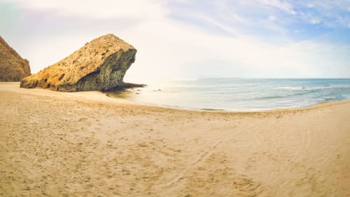 Golden rock formation on sandy beach at Hostal Las Dunas, Cabo de Gata Almería