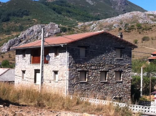 Edificio de piedra con tejado de barro en el paisaje montañoso de Salamón en Monte Roblo