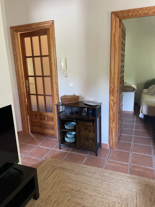 Pasillo interior del apartamento Monte Roblo con baldosas de terracota, puertas de madera, armario de almacenamiento y vistas a la montaña en Salamón
