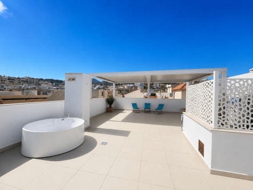 Luksusowy taras na dachu z jacuzzi, leżakami i widokiem na morze w Torremolinos