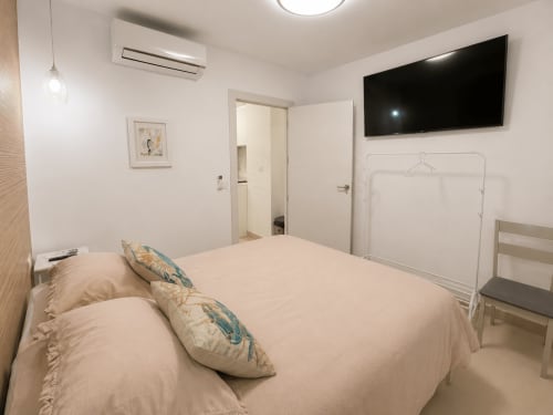 Nowoczesna sypialnia w apartamencie w Torremolinos z łóżkiem, telewizorem plaskim, klimatyzacją i łazienką