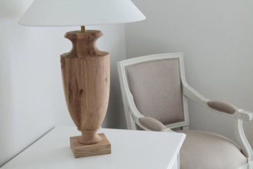 Lampada da tavolo in legno con paralume bianco accanto a poltrona imbottita nella camera doppia di B&B Le Biciclette, San Vito Lo Capo