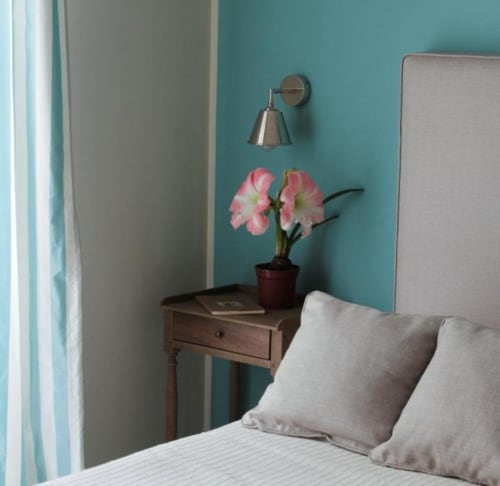 Camera da letto azzurra al B&B Le Biciclette con letto gemellare, comodino in legno e fiori rosa a San Vito Lo Capo