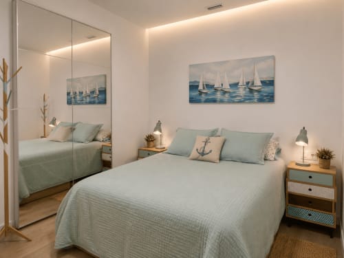 Jasna nowoczesna sypialnia w Alquileres Cantos de Sirena w Torremolinos z sztuką morską, szafą z lustrem i stylem nautycznym