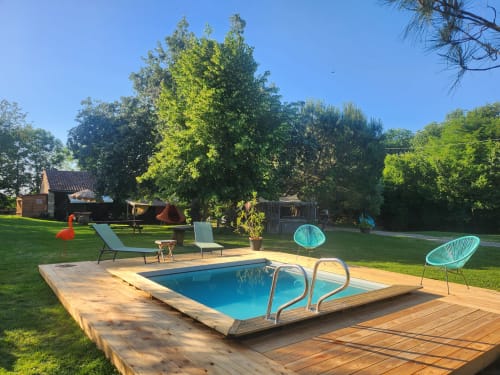 Área de piscina de Les Robinsonades con tumbonas turquesas, terraza de madera y jardines exuberantes en Saint-Christaud