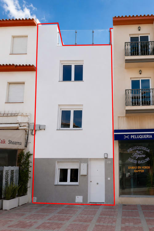 Biały budynek mieszkalny z czerwoną ramką w Torremolinos, Hiszpania, z wejściem prywatnym i widokiem na morze