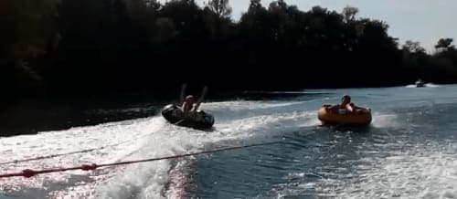 Tubing adventure on river near Les Robinsonades, Saint-Christaud with forested banks