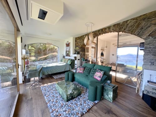 Luxury studio with teal sofa, bed, and panoramic Lake Maggiore views from terrace in Stresa, Italy