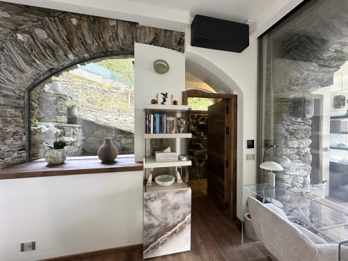 Luxury studio with stone archway, lake view terrace, modern shelving, and spa access at Lake Maggiore retreat
