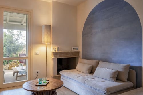 Modern bedroom at Top Villas Sardinia with arched accent wall, fireplace, and terrace overlooking Quartu Sant'Elena