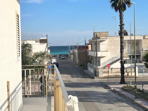 Vista della strada costiera di Il Corso Guest House a Veglie con architettura mediterranea, palma e mare turchese