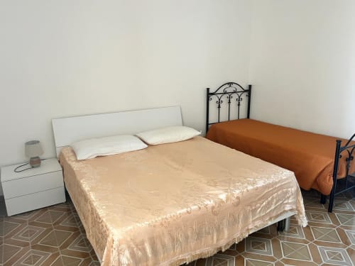 Camera spaziosa in Il Corso Guest House, Veglie, con letto, testiera bianca, lampada da comodino e pavimento in piastrelle