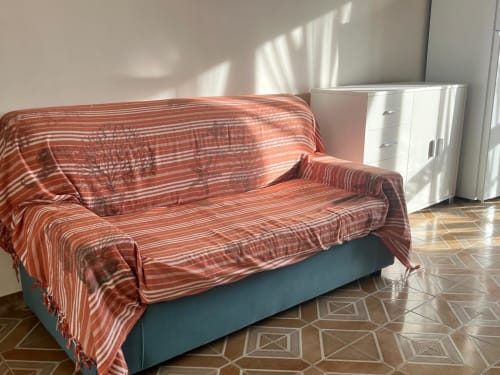 Divano a righe rosse con plaid in accogliente appartamento con pavimento geometrico a My Home Apulia, Veglie