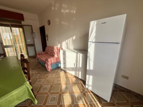 Cucina e zona living luminosa di Il Corso Guest House a Veglie con frigorifero bianco e divano rigato