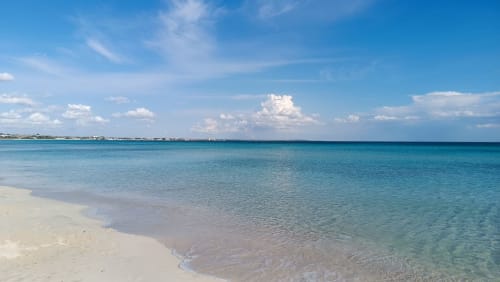 Spiaggia turchese incontaminata con sabbia bianca e acque tranquille a My Home Apulia a Veglie, Italia